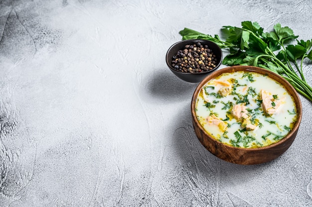 Romige vissoep met zalm, forel, aardappelen en peterselie. Grijze achtergrond, bovenaanzicht, ruimte voor tekst