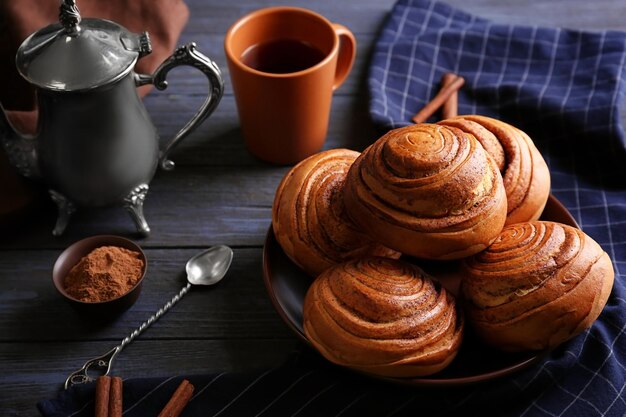 Rond bord met lekkere kaneelbroodjes op keukentafel