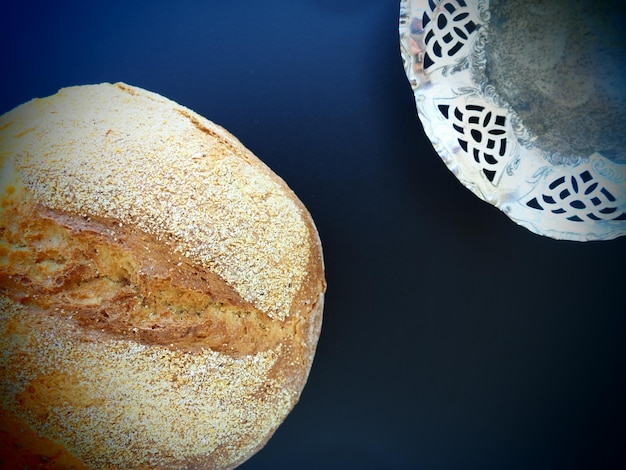 Rond brood bovenaanzicht Heerlijke verse maisbrood met hagelslag op een blauwe achtergrond metalen zilveren schaal zijaanzicht Kopieer ruimte Traditionele recepten Handgemaakt brood en snoep kom