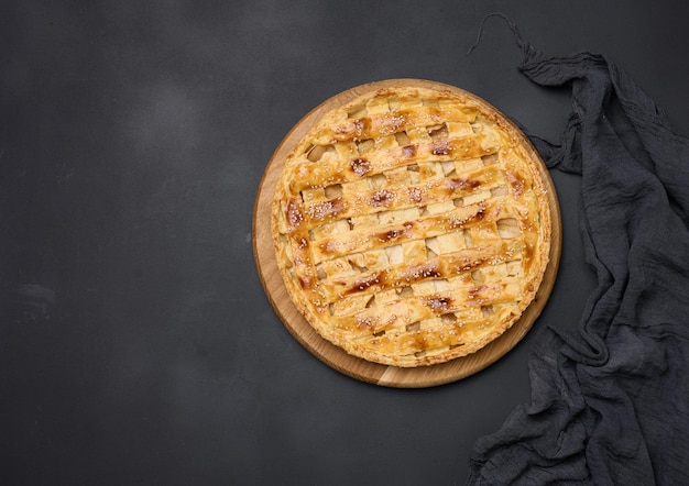 Rond gebakken appeltaart op een zwarte tafel Uitzicht van bovenaf