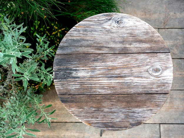 Rond houten tafelblad nabij groene bladeren