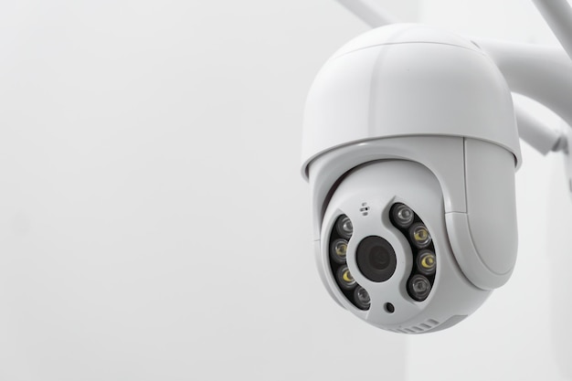 Ronde cctv-camera met antennes schiet video op de witte muur