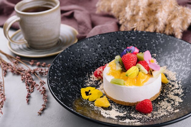 Ronde cheesecake met fruitdecoratie en kopje koffie