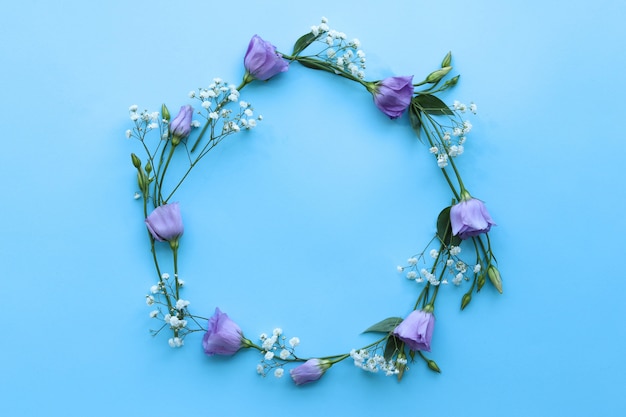 Ronde frame van bloemen op een blauwe tafel, de basis voor de ontwerp gefeliciteerd, het bovenaanzicht