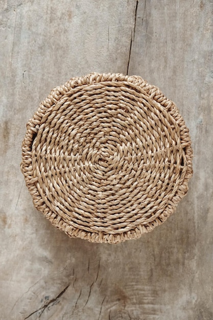 Foto ronde rieten mand op een oude houten achtergrond. bovenaanzicht. kopiëren, lege ruimte voor tekst