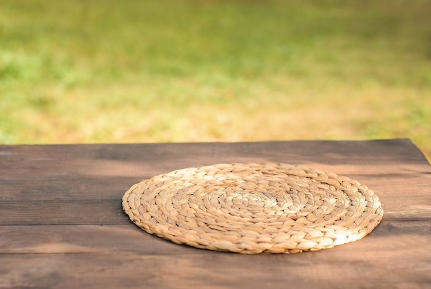 Ronde rieten servet voor bestek op een houten tafel