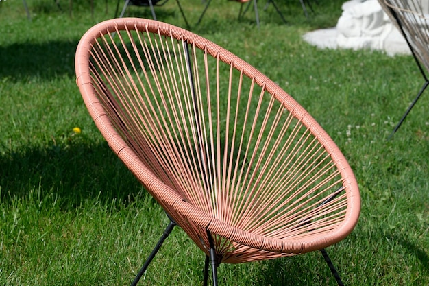 Ronde rieten zomerstoelen op het gazon voor een openluchtcafé