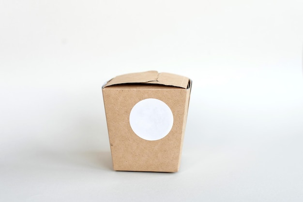 Ronde sticker mockup op kraft doos lunchbox verpakking met blanco sticker zelfklevend etiket