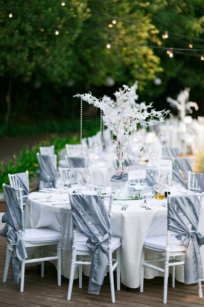 Ronde tafels met een witte stof tafelkleed witte chiavari stoelen met draperie grijze stof met een