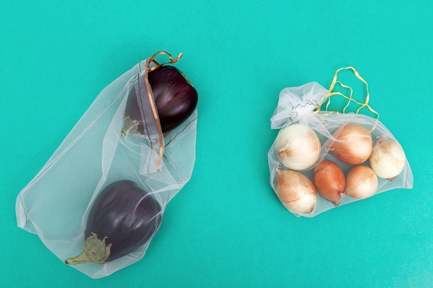 Ronde uien en verse rijpe aubergines in eco natural bags