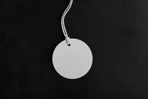 Ronde white tag label mockup met wit koord close-up Blanco papier prijskaartje geïsoleerd op zwarte achtergrond met kopie ruimte Verkoop en Black Friday concept