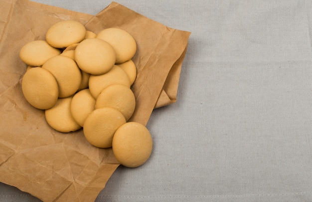 Ronde zelfgemaakte koekjes bovenaanzicht op donkere achtergrond. gemorste koekjes met inpakpapier