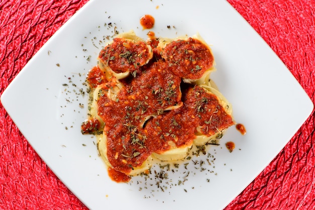 Rondelli topped with red sauce and sprinkled with spices.