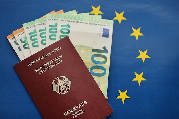 Rood Duits paspoort van de Europese Unie en geld op blauwe achtergrond close-up