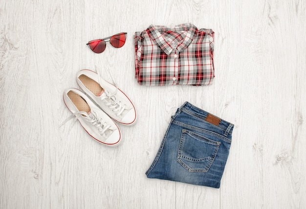 Rood en wit geruit hemd, bril, sneakers en jeans