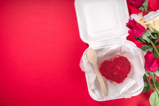 Rood fluwelen hartvormige valentijn bento cake, zoet dessert verrassingscadeau voor valentijnsdag bovenaanzicht, met rozen, champagne