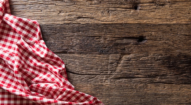 Rood geruit keukentafelkleed op rustieke houten tafel.