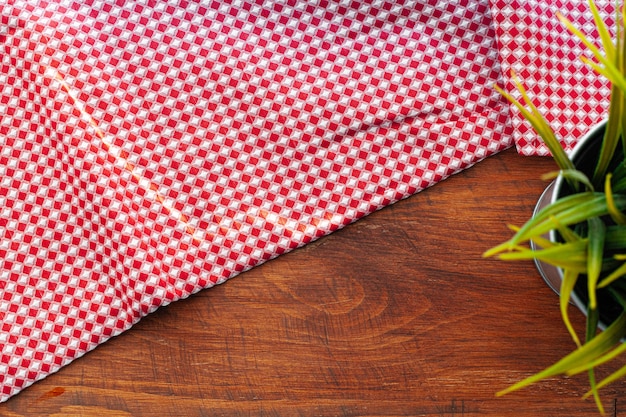 Rood geruit servet of tafellaken op houten tafel, kopie ruimte