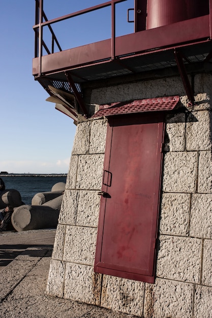 Rood geschilderde ijzeren deur die behoort tot de vuurtoren in de dam van Sottomarina in Veneto, Italië.