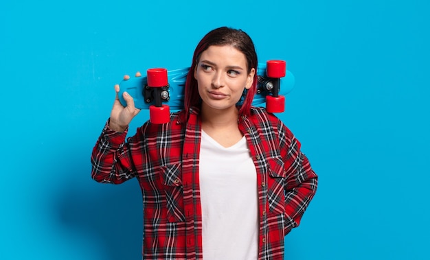 Rood haar koele vrouw met een skate board