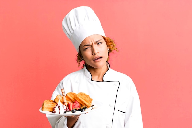 Rood haar mooie chef-kok vrouw kokende wafels