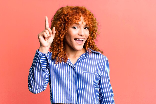 Foto rood haar mooie vrouw tegen geïsoleerde achtergrond