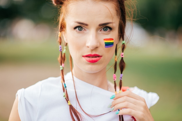 Foto rood haarmeisje met lgbt vrolijke trotsvlag op haar portret van de gezichtsclose-up.