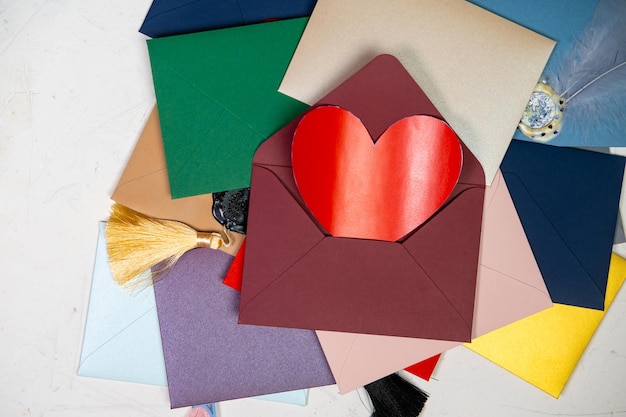 Rood hart in een envelop Veel kleurrijke enveloppen Enveloppen verzegeld met was Correspondentie Valentijnsdag concept