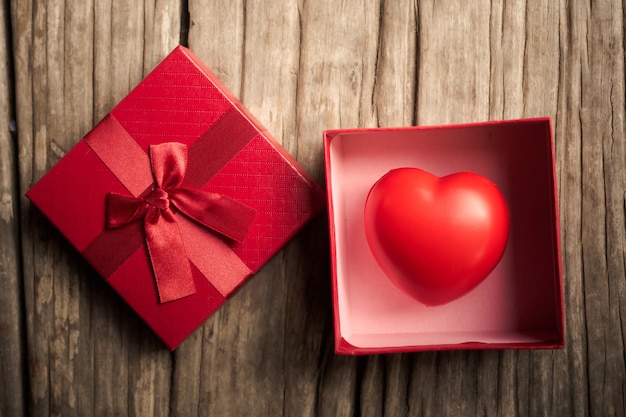 Rood hart in geschenkdoos op houten plank. Concept voor valentijnskaartdag.