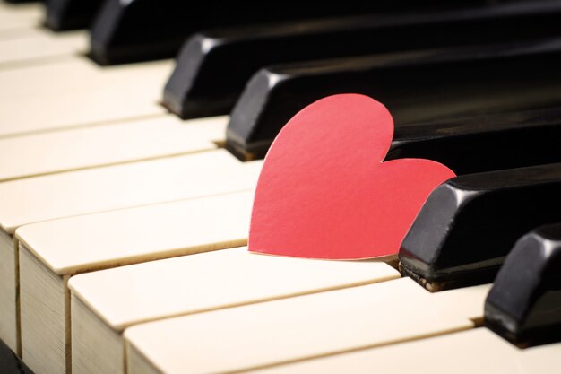 Rood hart op toetsen van een toetsenbord van een klassieke oude piano.