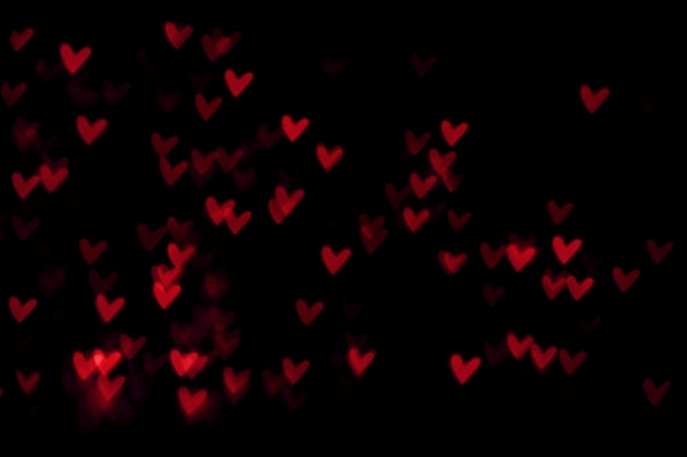 Rood hart valentijn bokeh lichten tegen een zwarte achtergrond