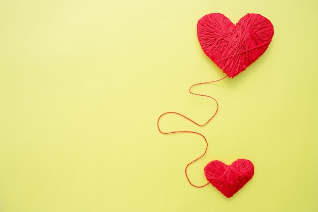 Rood hart vorm symbool gemaakt van wol geïsoleerd op gele achtergrond Hartvormige wollen garen liefde Crochetheart als een symbool van liefde Hobby breien Kopieer ruimte