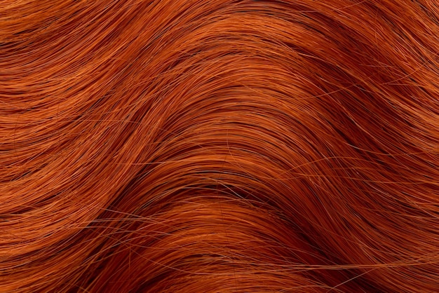 Foto rood krullend lang haar close-up een golf van haar als achtergrond