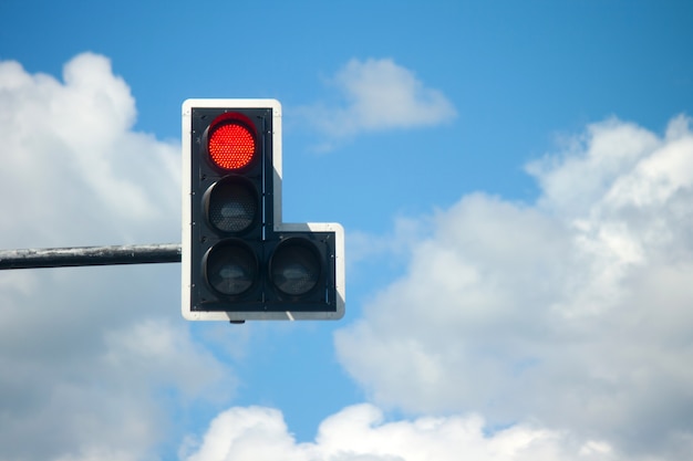 Rood lichtverkeerslichten tegen blauwe hemel.