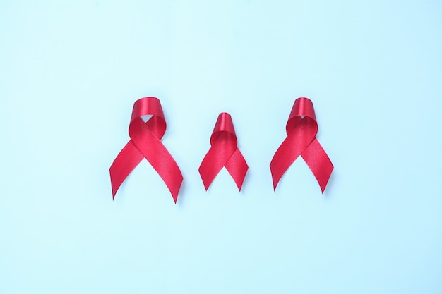 Rood lint samengesteld uit symbolen van aids tegen hiv-virus geïsoleerd op blauwe achtergrond