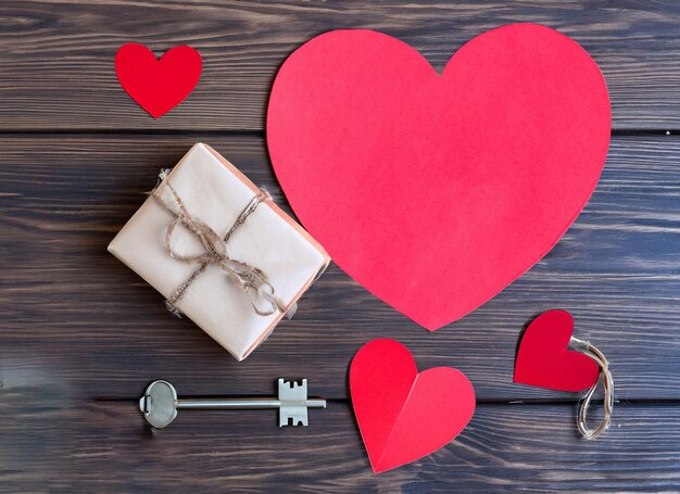 Rood papier hart en oude sleutel op een donkere houten achtergrond Valentijnsdag Kopieer ruimte