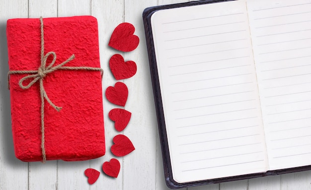 Rood papieren hart en geschenkdoos op houten tafel