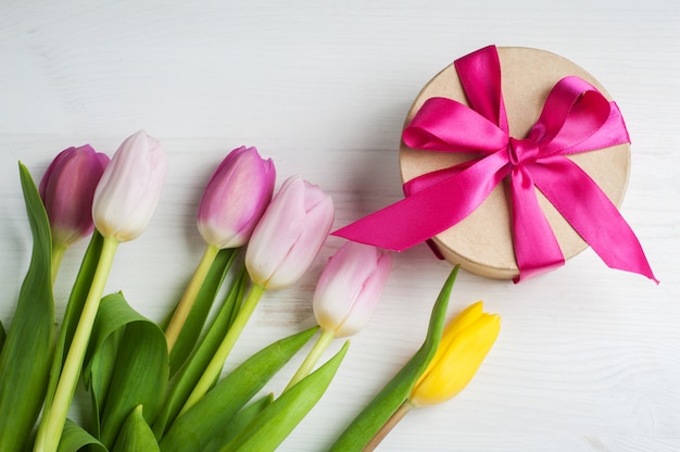 Rood roze gele tulpen en geschenkdoos met rood lint