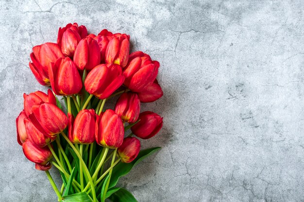 Rood tulpenboeket op betonnen ondergrond