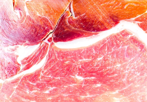 Rood vlees textuur close-up foto. Italiaanse prosciutto crudo of jamon. Rauwe ham. Varkensvlees achtergrond.