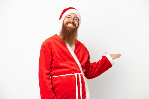Roodachtige man vermomd als de kerstman geïsoleerd op wit zijn handen naar de zijkant uitstrekkend om uit te nodigen om te komen