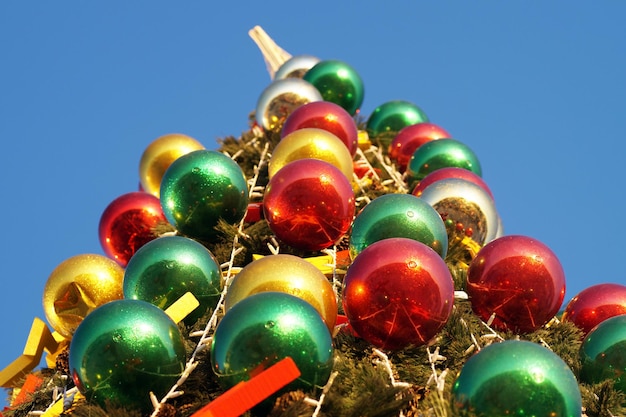 Roodgouden groene ballonnen op de stadskerstboom op een zonnige dag