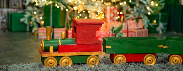 roodgroene houten trein onder de kerstboom Prettige kerstdagen en gelukkig nieuwjaar concept