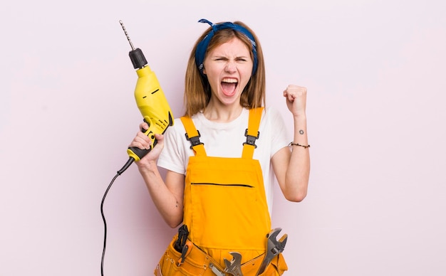 Roodharig mooi meisje dat agressief schreeuwt met een boos concept voor woningrenovatie