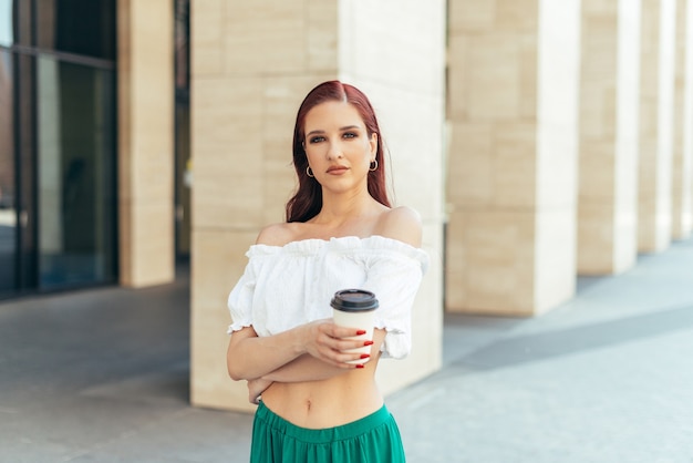 Roodharige blanke vrouw met een kopje koffie.