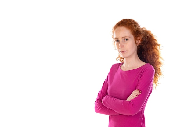 Roodharige jonge vrouw die een roze t-shirt draagt