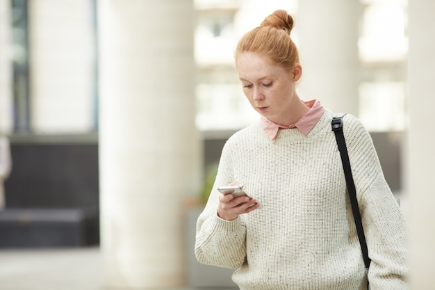 Roodharige jonge vrouw in de stad