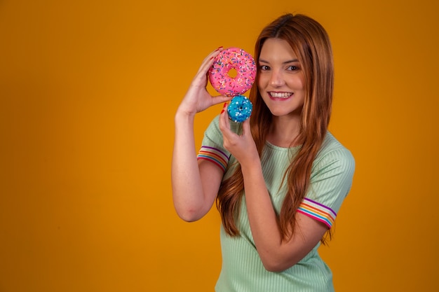 Roodharige jonge vrouw met donuts