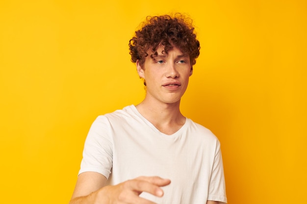 Roodharige man in een wit t-shirt op een gele achtergrond