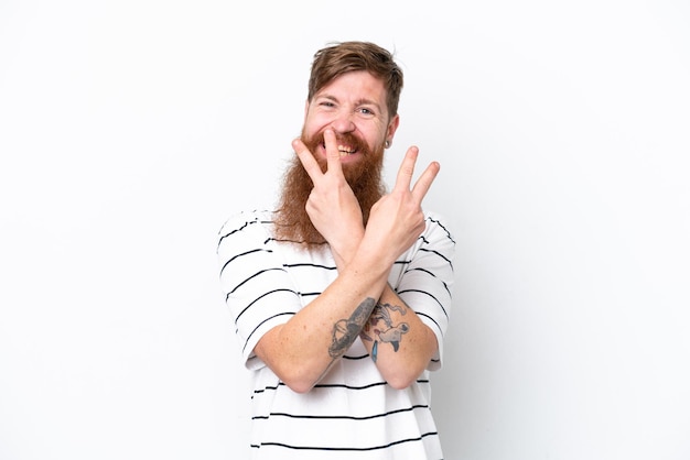 Roodharige man met baard geïsoleerd op een witte achtergrond glimlachend en overwinningsteken tonen